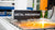 Metal innovation display with laser equipment producing sparks in a manufacturing setting.